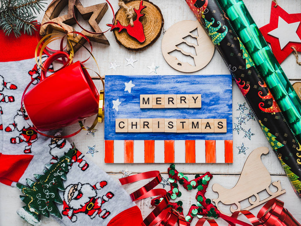 Christmas card. Colorful Christmas decorations and toys, drawing of USA Flag, warm socks with Santa Claus, red mug and ribbon on a white, wooden surface. Merry Christmas! Top view, close-up, flat lay - Foto, Bild