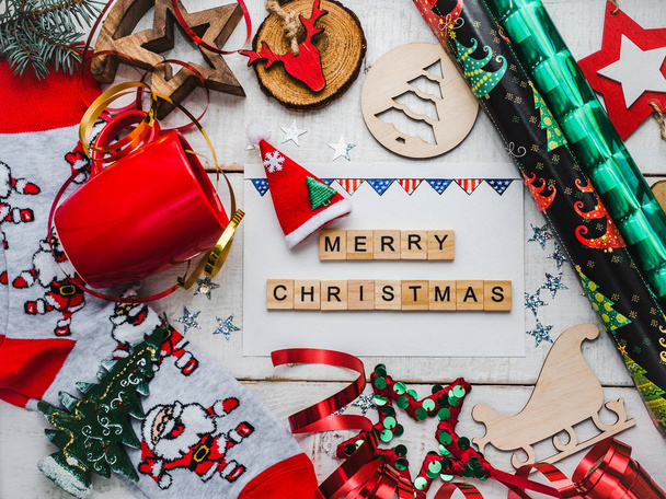 Christmas card. Colorful Christmas decorations and toys, drawing of USA Flag, warm socks with Santa Claus, red mug and ribbon on a white, wooden surface. Merry Christmas! Top view, close-up, flat lay - Foto, afbeelding