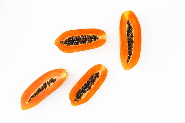 Fetta di papaia su sfondo bianco. Piatto. Vista dall'alto. Concetto di frutta
 - Foto, immagini