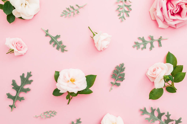 Virágos mintával készült, a rózsa és a levelek a pasztell rózsaszín háttér. Lapos feküdt, top view. - Fotó, kép