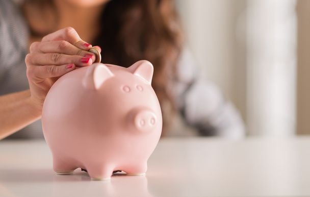 Woman Putting Coin In Piggy Bank - Photo, Image