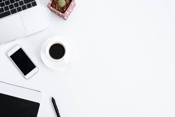 Graphic Designer table de travail blanche avec ordinateur, cactus, café, téléphone et stylo pour un travail acharné le matin avec vue sur le dessus. Concept de vue de bureau
. - Photo, image