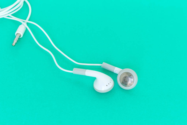 earbuds or earphones on green background - Photo, Image