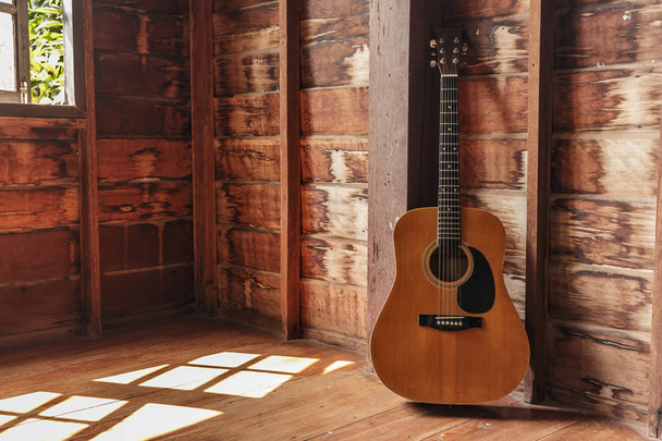 Vieille guitare classique dans la chambre sur mur en bois
. - Photo, image