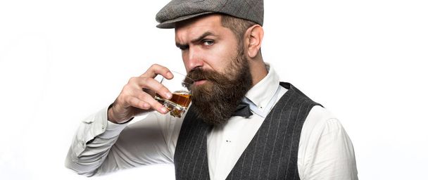 Sommelier chutná drahé pití. Hezký-oblečený muž v saku s sklenici nápoje. Vousatý muž na sobě oblek a pít whisky, brandy, koňak. Vousatý v je drží sklenku whisky - Fotografie, Obrázek