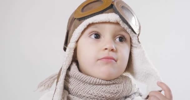 video of playful adorable little girl dressed as pilot in hat and glasses  - Кадры, видео