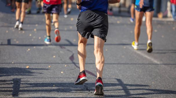 Maraton käynnissä rodun, ryhmä juoksijoita kaupungin teillä, peruutusnäkymä
 - Valokuva, kuva