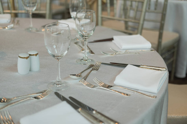 Елегантно освітлений святковий обідній стіл з келихами для вина
 - Фото, зображення