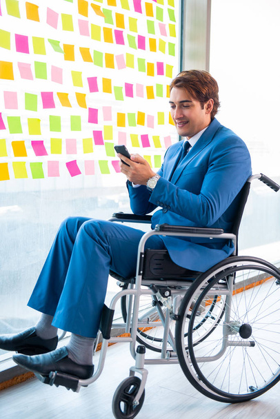 Młody przystojny mężczyzna na wózku inwalidzkim z wieloma sprzecznymi priorytetami - Zdjęcie, obraz