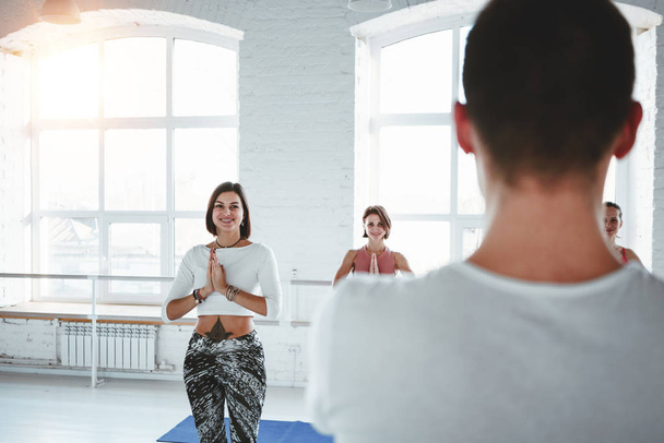 Young fitness trainer teaches a group of women to do yoga. Healthy lifestyle concept. Fitness Exercise - Fotoğraf, Görsel