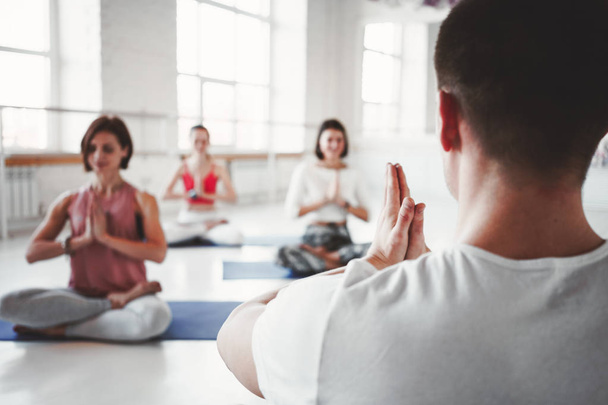 Yoga kız pratik grup egzersiz birlikte kapalı sınıf. Sağlıklı yaşam konsepti - Fotoğraf, Görsel