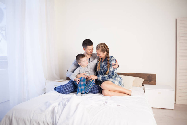 mom dad and young son in the morning in bed after sleeping - Foto, imagen