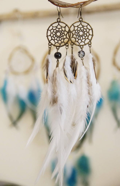 handgefertigte Ohrringe im Traumfänger-Stil mit Federn und Bronzebeschlägen - Foto, Bild