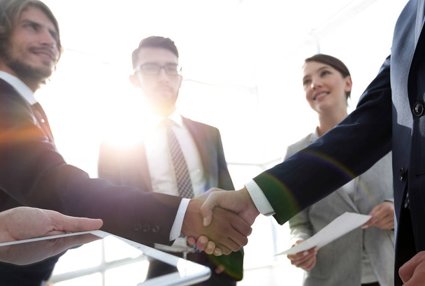 employees look at the handshake business partners - Photo, Image