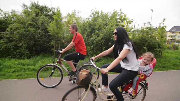 Ouders met hun kinderen rijden op de fiets. Gelukkige familie samen tijd doorbrengen. - Video