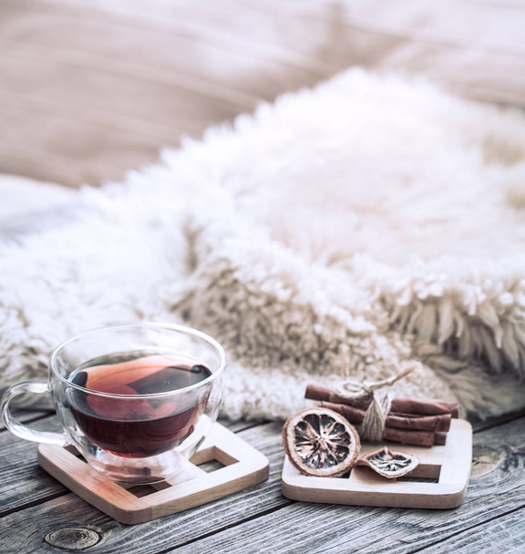Still life cozy atmosphere with a cup of tea and dried lemon on a wooden background - Photo, Image