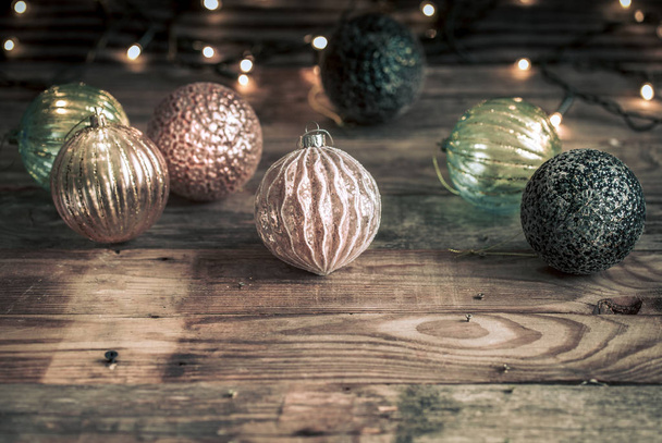 Χριστούγεννα ή Πρωτοχρονιά εορταστική φόντο, vintage παιχνίδια για το χριστουγεννιάτικο δέντρο σε ένα ξύλινο φόντο με μια γιρλάντα με φώτα - Φωτογραφία, εικόνα