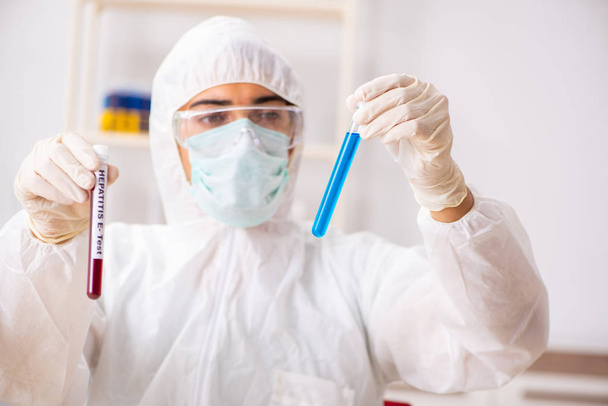 Fiatal jóképű laboratóriumi asszisztens vérmintákat tesztel a kórházban  - Fotó, kép