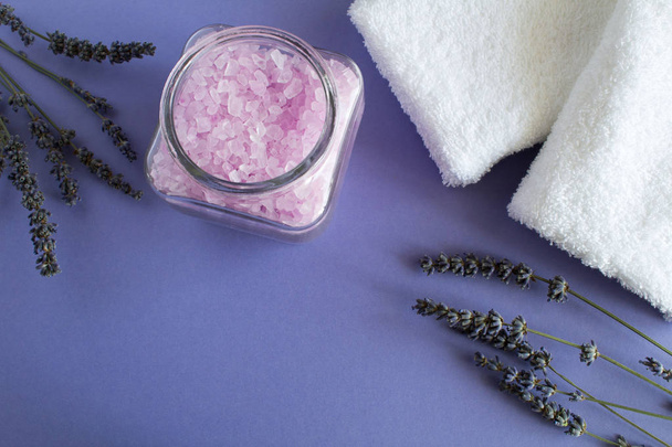 Lavender salt  in the glass jar and white towels on the violet   background.Top view. - Photo, Image