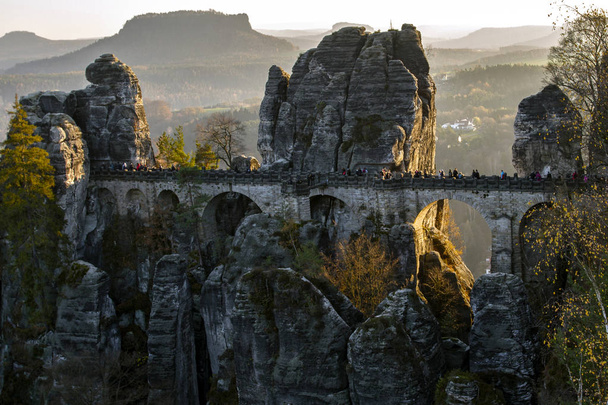 The Bastei bridge  in Saxon Switzerland National Park over the river Elbe. East Germany, Europe. Popular tourist attraction. Adventure vacation. European travel. . - Photo, image