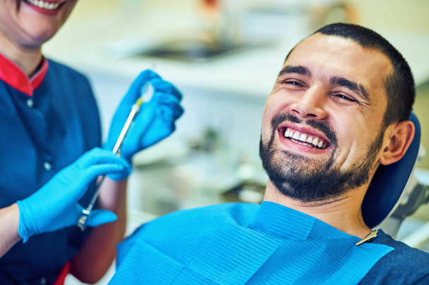 Smiling and satisfied patient in a dental office - Zdjęcie, obraz