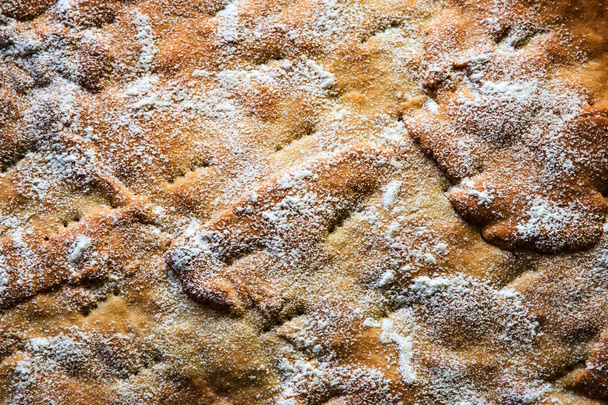 φόντο ή υφή ανώμαλη επιφάνεια του κέικ πασπαλισμένο με ζάχαρη - Φωτογραφία, εικόνα