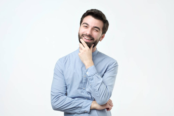 Portrait d'un bel homme hispanique heureux à la mode en chemise bleue regardant la caméra
 - Photo, image