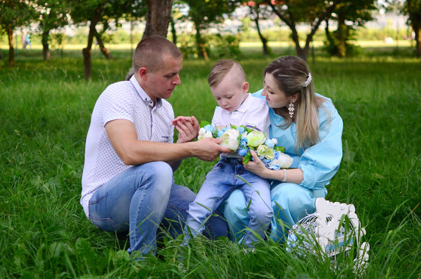 Happy family together in summer garden/park. Parents with their son Outdoor photo - Fotoğraf, Görsel