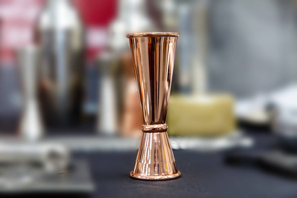 Copper jigger for cocktails is on the bar. - Photo, Image