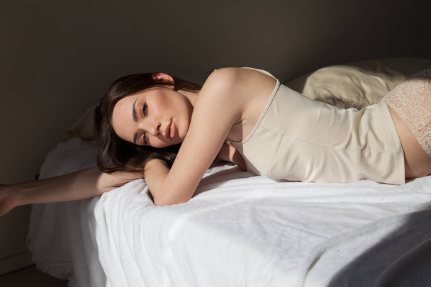 Портрет красивой женщины в нижнем белье на кровати музыки
 - Фото, изображение