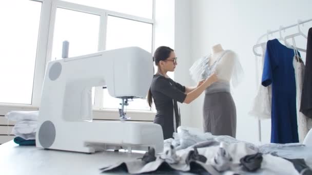 Koncepcja produkcji małych i małych firm. Kobieta młody ładny krawcowej szyje ubrania w warsztacie - Materiał filmowy, wideo