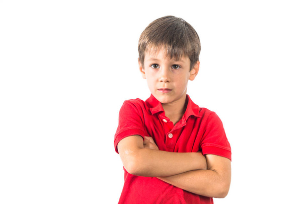 Kaukasischer Junge im roten T-Shirt blickt ernst in die Kamera - Foto, Bild
