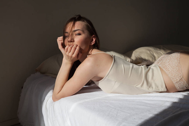 Portrait of beautiful woman in lingerie on bed music - 写真・画像