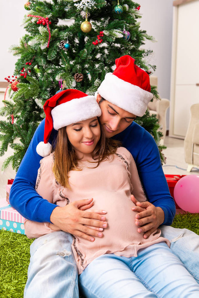 Embarazada esposa celevrating Navidad con marido - Foto, Imagen