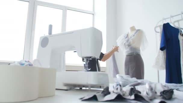 concept van kleine bedrijven en kleine productie. Jonge mooie naaister vrouw naait kleren in de werkplaats - Video