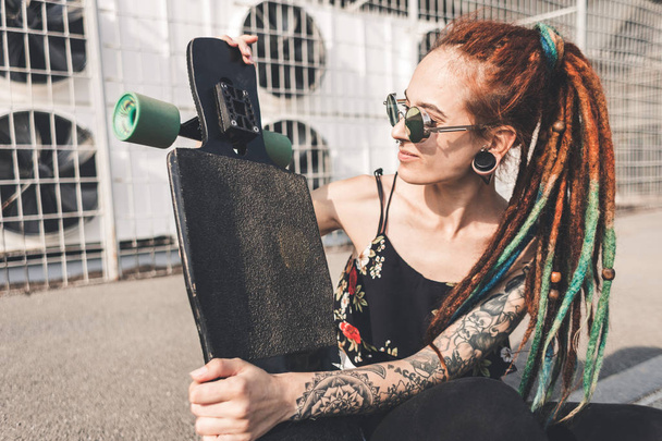 young girl with tattoo and dreadlocks on urban industrial background - Photo, Image