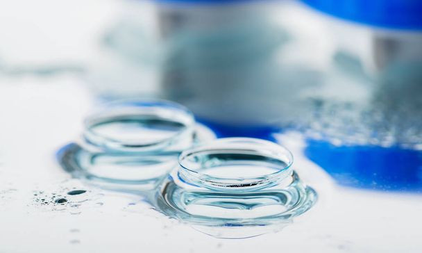 Container for contact lenses. Reflection on glass table - 写真・画像