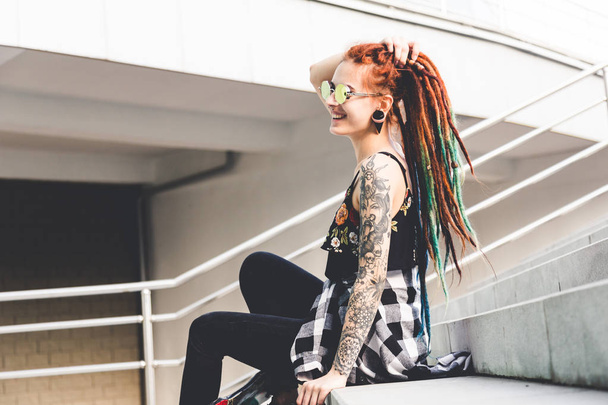 young girl with tattoo and dreadlocks sitting on the steps - Zdjęcie, obraz