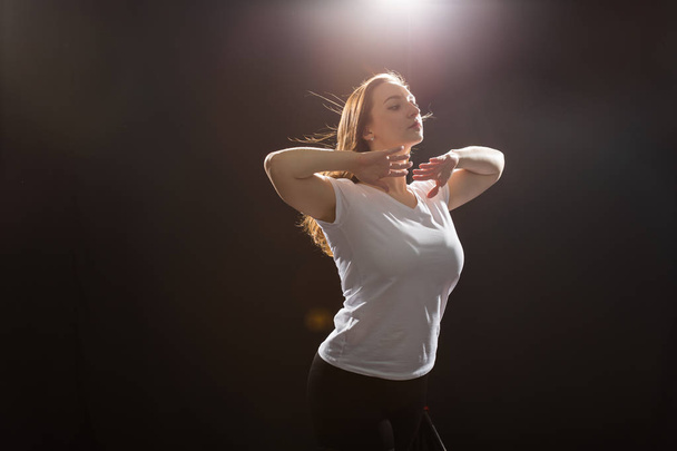 Menschen und Tanzkonzept - junge schöne sportliche Frau tanzt Jazz-Funk auf schwarzem Studiohintergrund - Foto, Bild