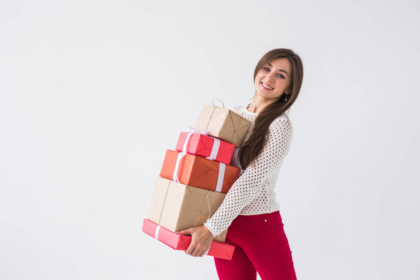Christmas and holidays concept - woman with many gifts on white background with copy space - Photo, Image