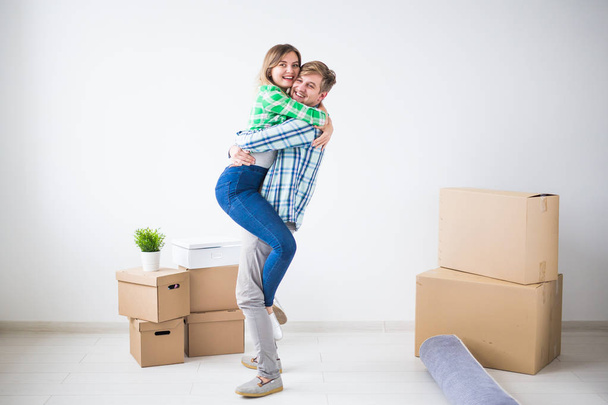 Deslocalização, imobiliário e conceito em movimento - Jovem casal alegre se mudando para sua nova casa
 - Foto, Imagem