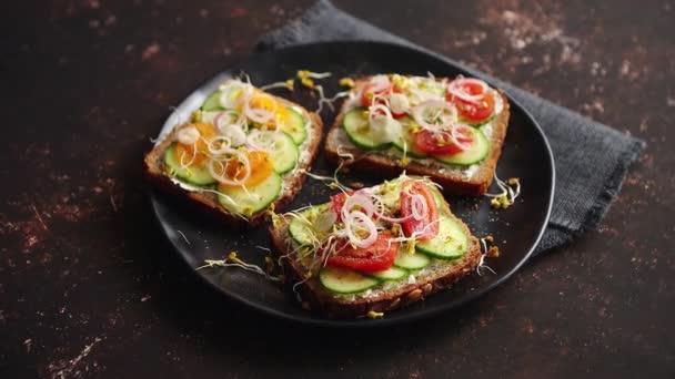 Gezonde toastjes met komkommer, tomaten en gemalen feta en radijs spruiten - Video
