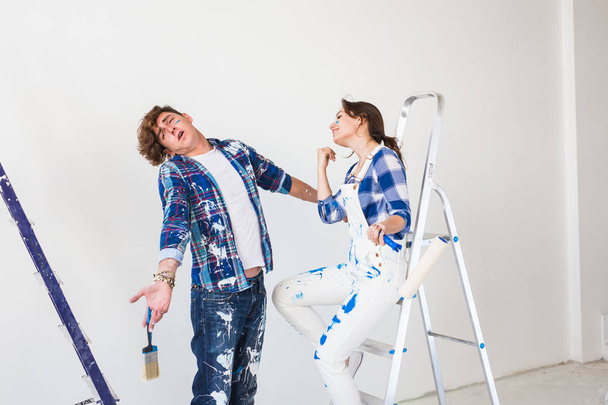 Teamwork and repair concept - young couple doing a renovation in new apartment - 写真・画像