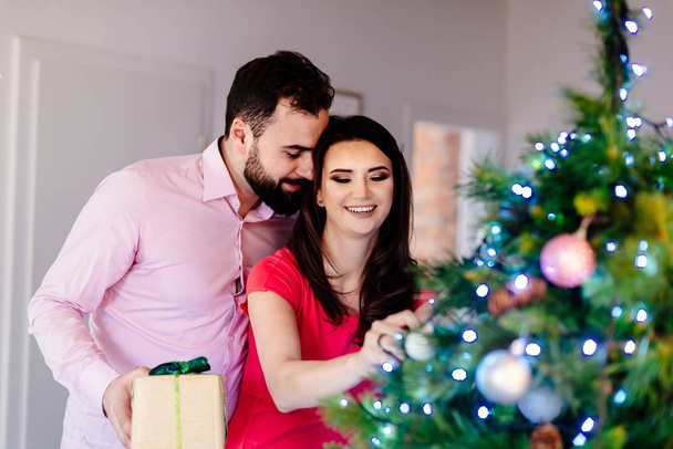 Happy couple decorating Christmas tree. Merry Christmas! - Photo, Image