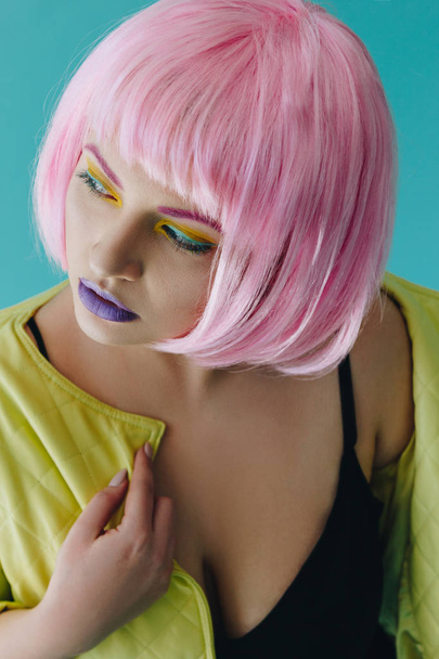 Krásná mladá žena s růžovými vlasy na modrém pozadí - Fotografie, Obrázek