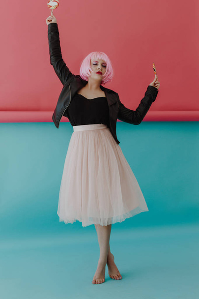 Beautiful young woman with pink hair in studio - 写真・画像