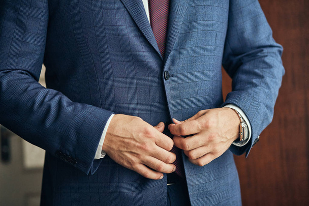 Businessman wears a jacket,male hands closeup,groom getting ready in the morning before wedding ceremony - Foto, afbeelding
