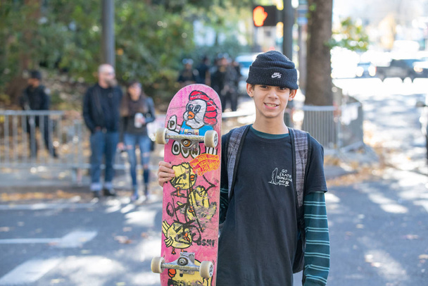 Portland, nebo / Usa - 17 Listopad 2018: mladý muž teenager s skateboardu přes křižovatku v centru politického protestu. - Fotografie, Obrázek