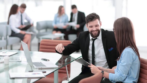 pareja de negocios discutiendo documento de trabajo sentado en el escritorio
 - Foto, Imagen