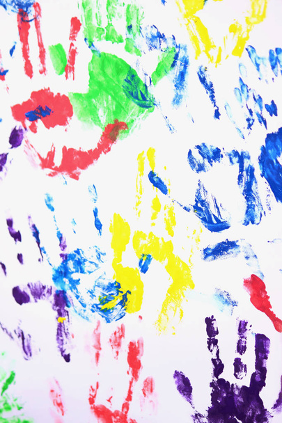 värikkäät kädenjäljet valkoisella taustalla ryhmätyön symbolina
 - Valokuva, kuva